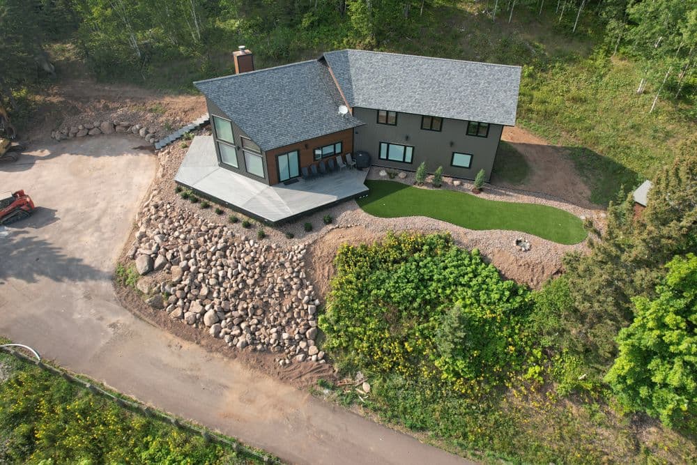 Aerial view of a modern home surrounded by landscaped rock and greenery.